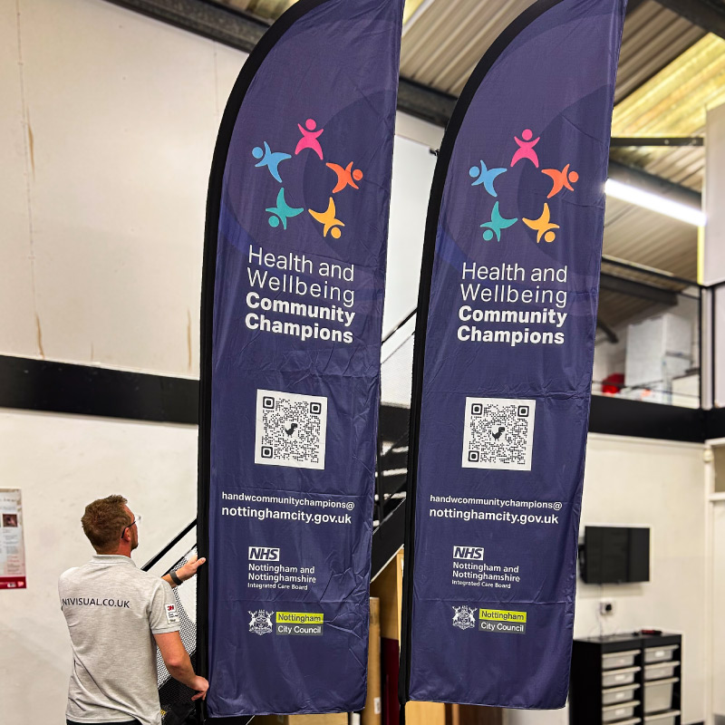 Two large flags advertising and congratulating the Nottingham City Council Health and Wellbeing Champions