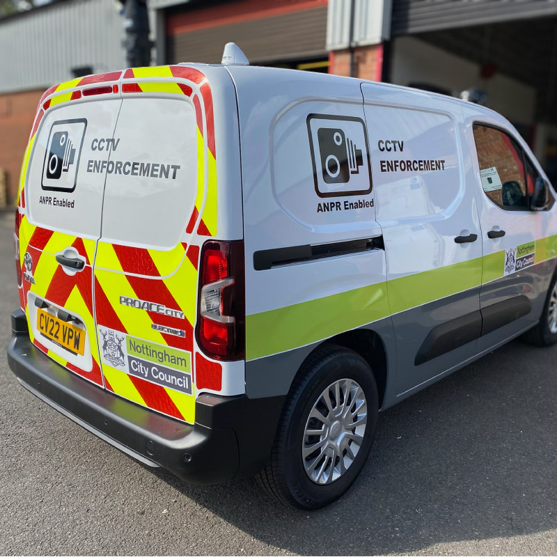 A white Nottingham City Council van with the side wrapped lower third in grey with a green stripe above. The rear doors have reflective chevrons in red and yellow.