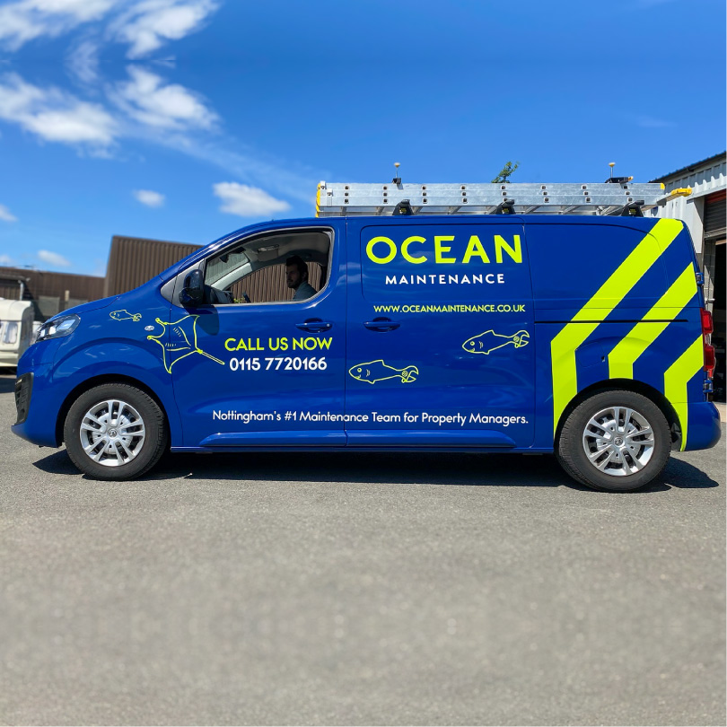 A Van wrapped blue with bright green house shaped logo. There are sea creatures illustrated as maintenance tools e.g. a hammer head shark