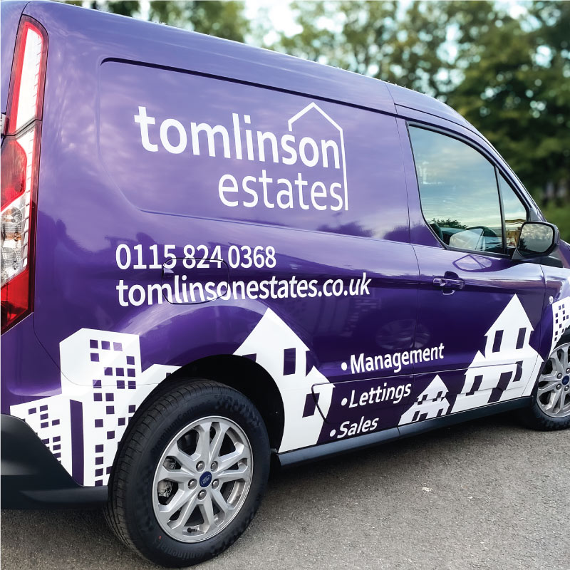 Small van wrapped in purple with white graphics. The graphics show buildings along the bottom, the company's logo and services above.