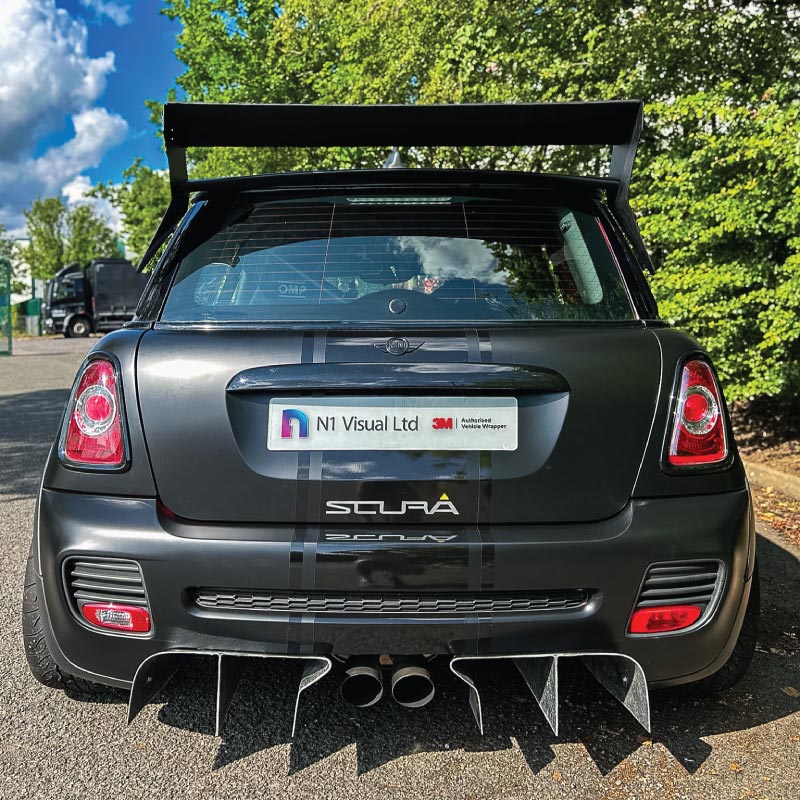 A matt black wrapped mini with gloss black motorsport stripe and graphics