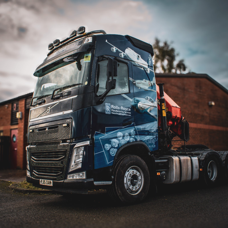 The printed wrap shows Rolls Royce engineering blueprints around the wheel.