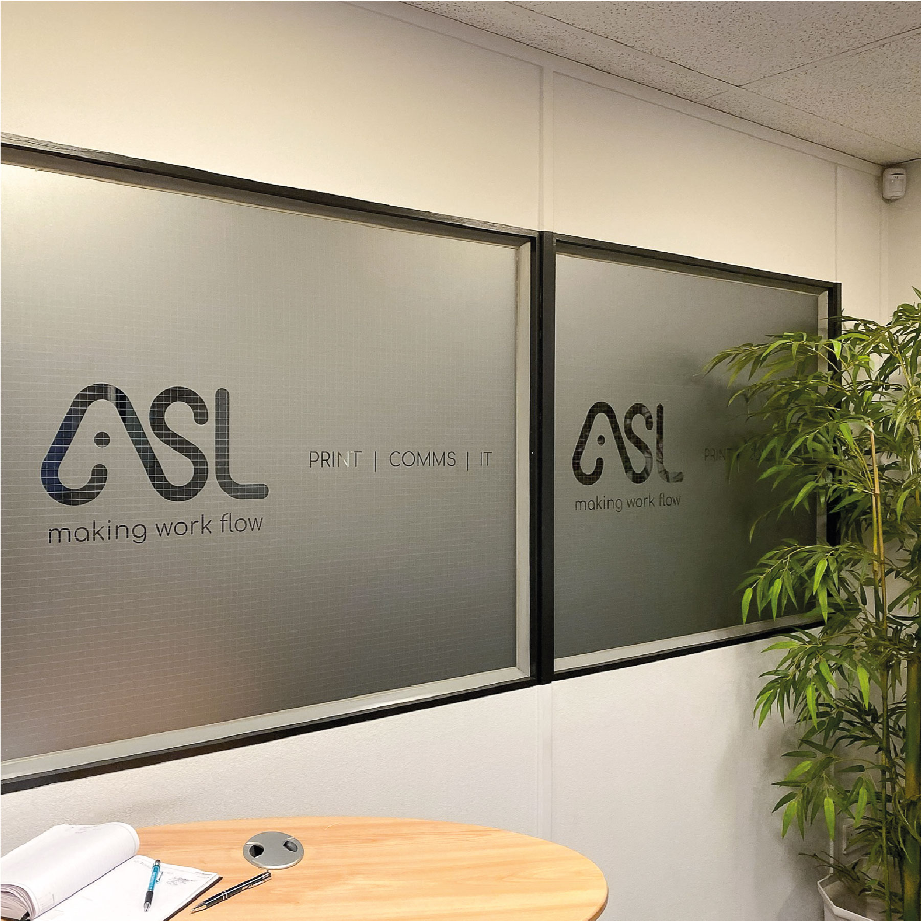 Two internal office windows that are fully frosted. The Frosting has the 'ASL' Logo cut from it.