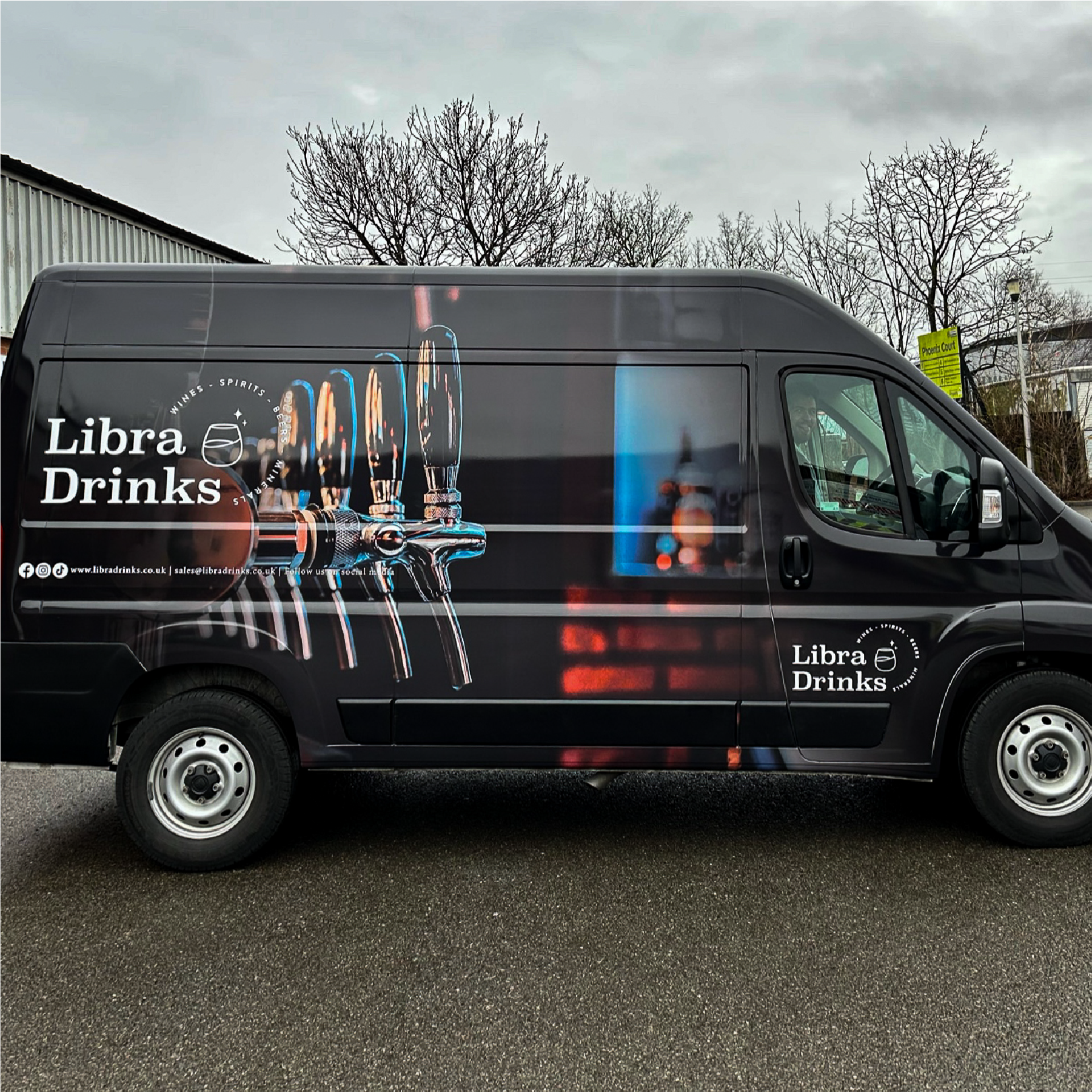 Van wrapped black with a photo of beer taps with white Libra Drinks branding over the top.