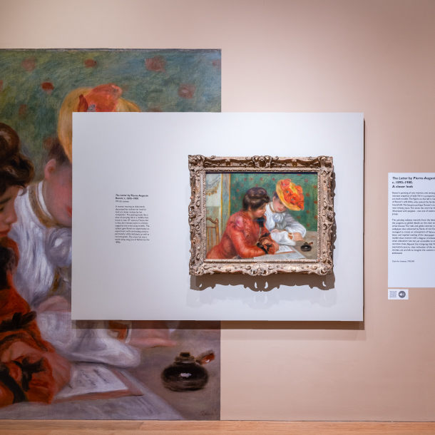 The image shows a wall in an art gallery, The creme wall has a partial wrap of a famous painting. Over the top of the partial wrap is a white rectangular board with the original framed painting on the right and to the left a small paragraph of black text with information about the painting and artist.