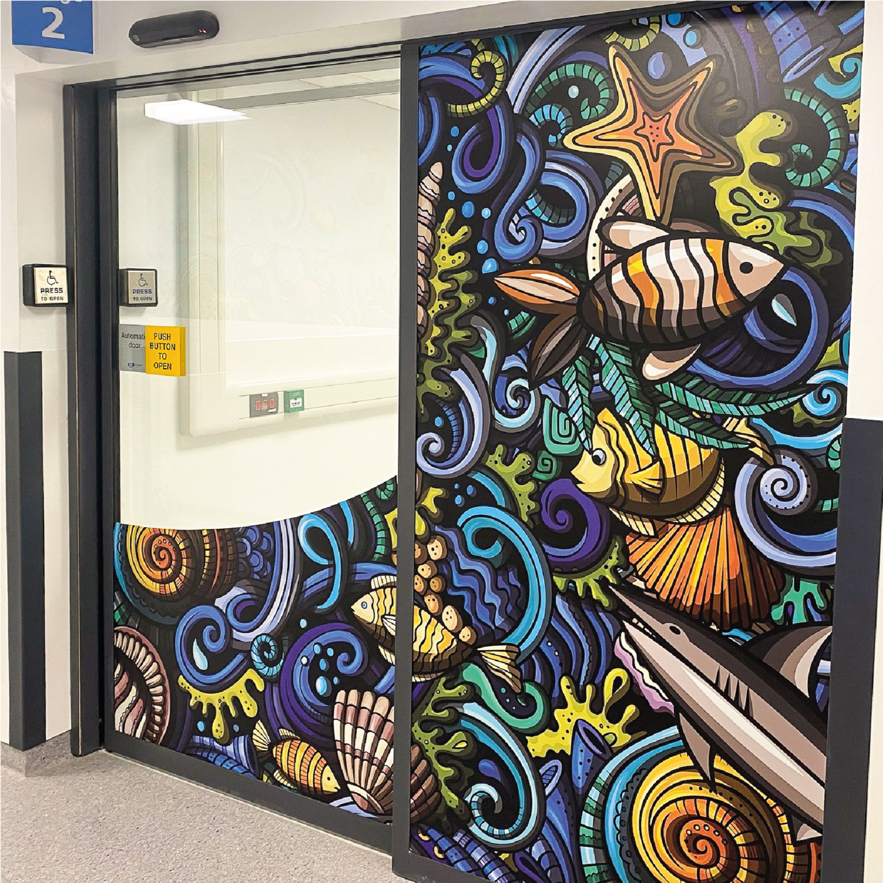 The sliding door and window to a triage room is wrapped with fun illustrations of sea creatures.