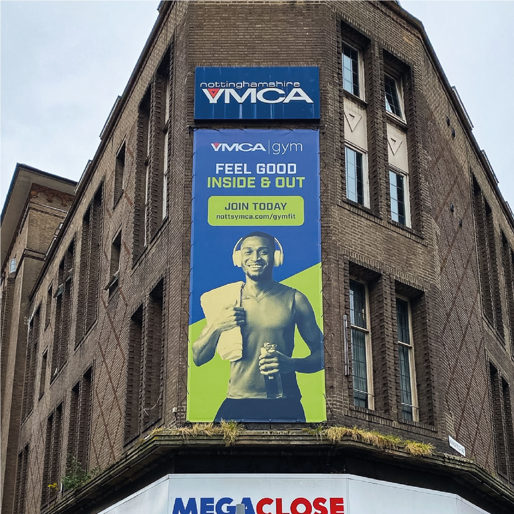 Large portrait banner advertising YMCA gym with a green and blue toned image of a gym-goer.